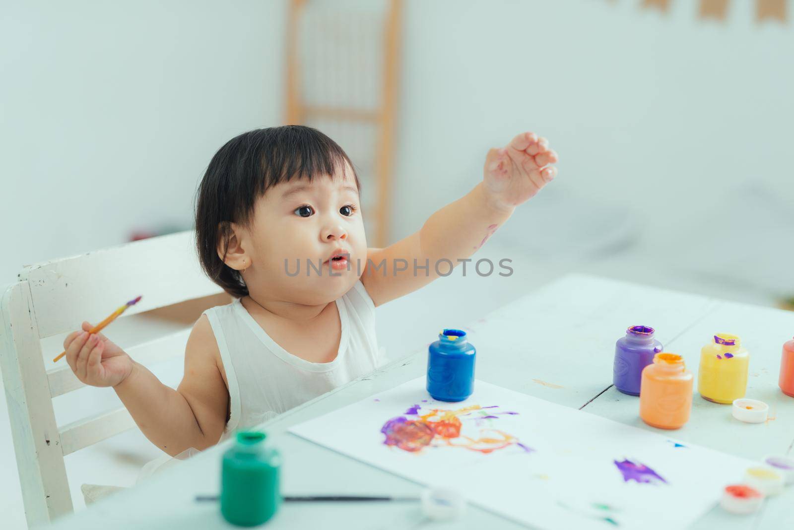 Healthy happy daughter experimenting with colors, water at home 