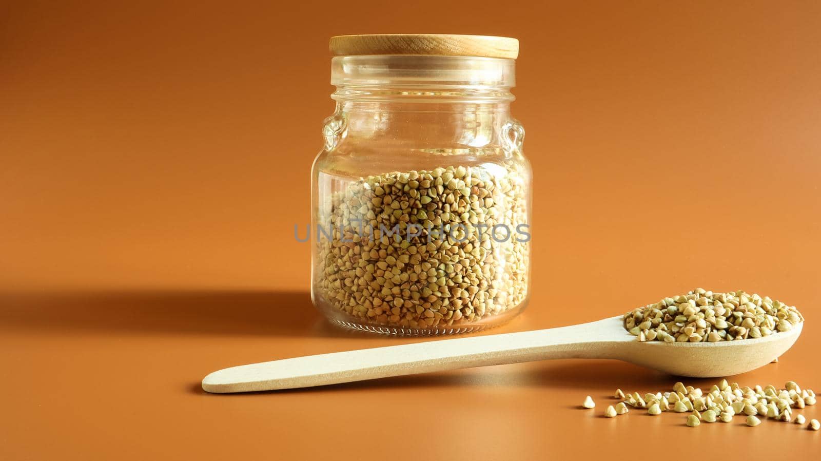 Green buckwheat sprouts in a glass jar with a wooden spoon. Raw vegan food concept. Organic food. The concept of diet, weight loss, healthy and proper nutrition. Copy space. Space for text