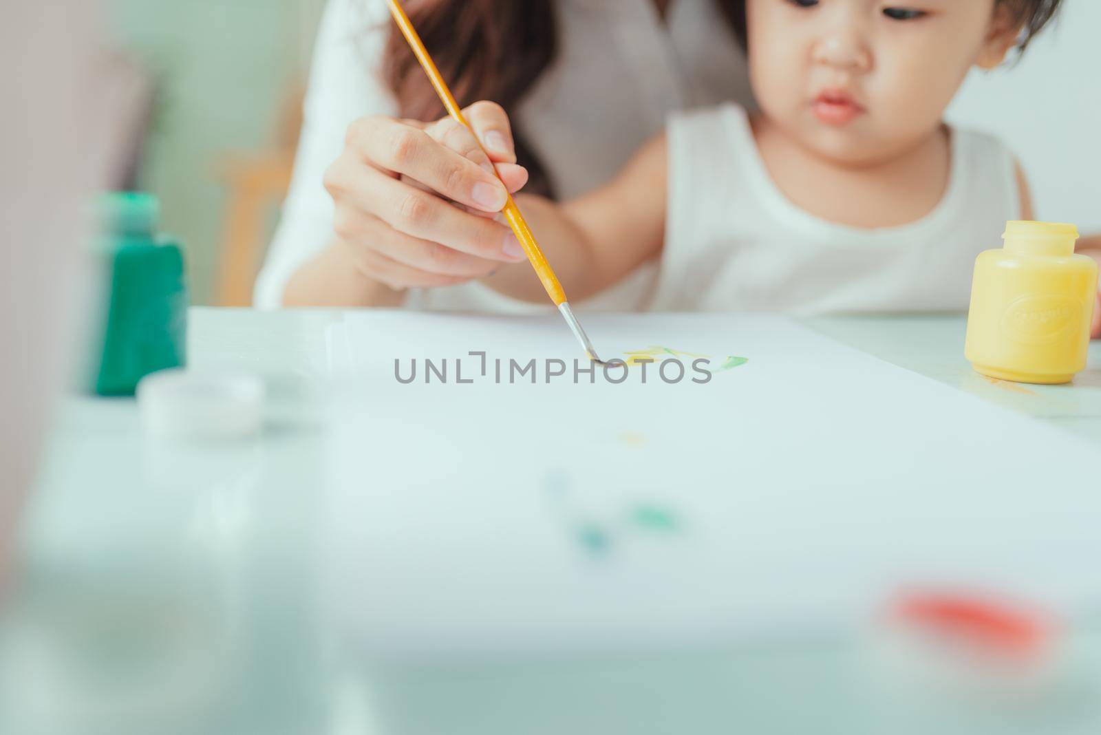 Mother and daughter have a fun painting with watercolor paints by makidotvn