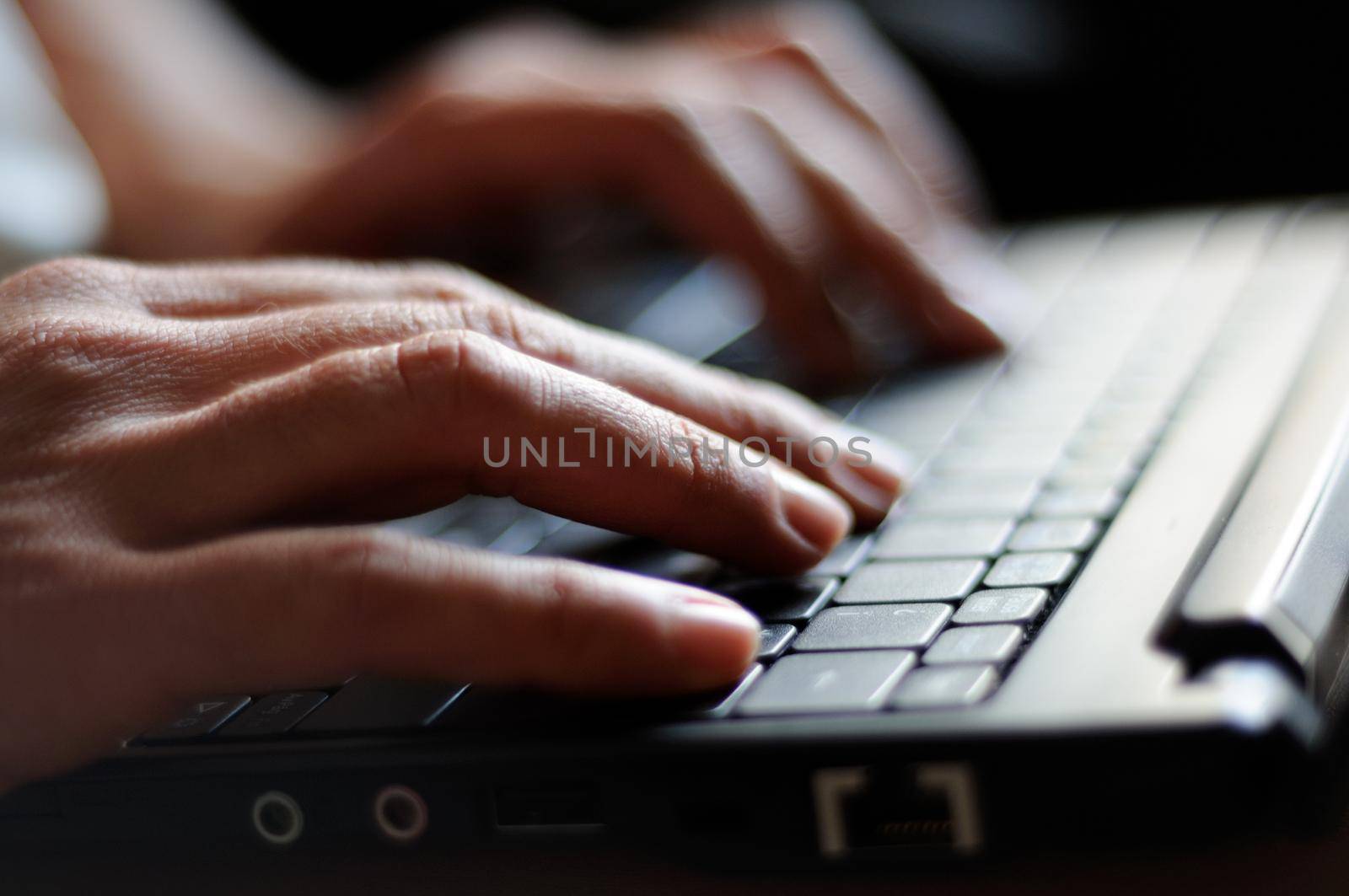 woman's hands typing on a laptop