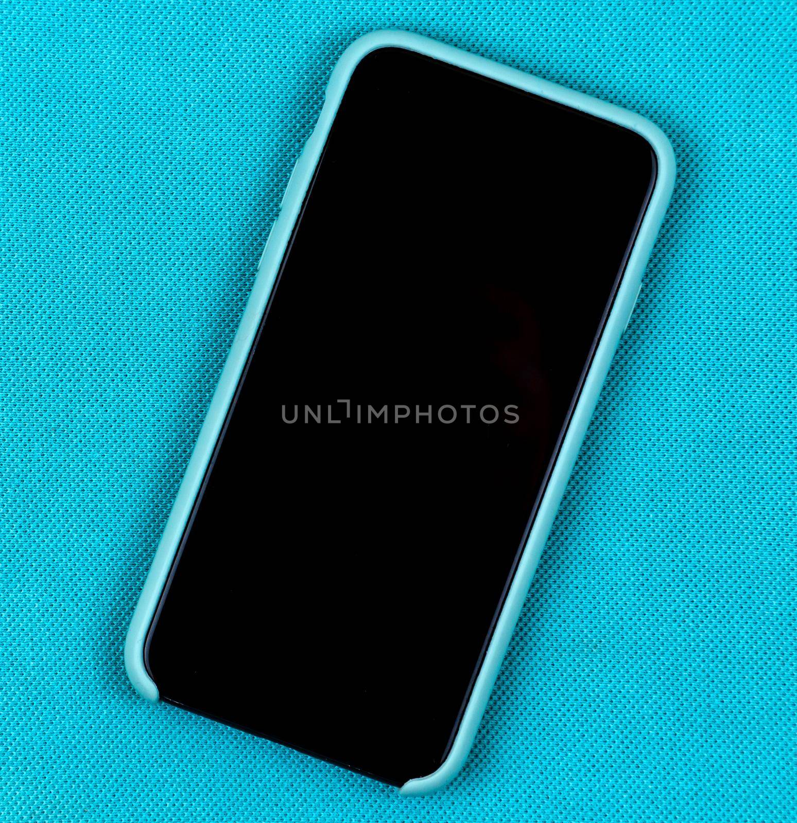 Black Mobile phone or smartphone in aqua blue case on a trendy aqua background with space for text.
