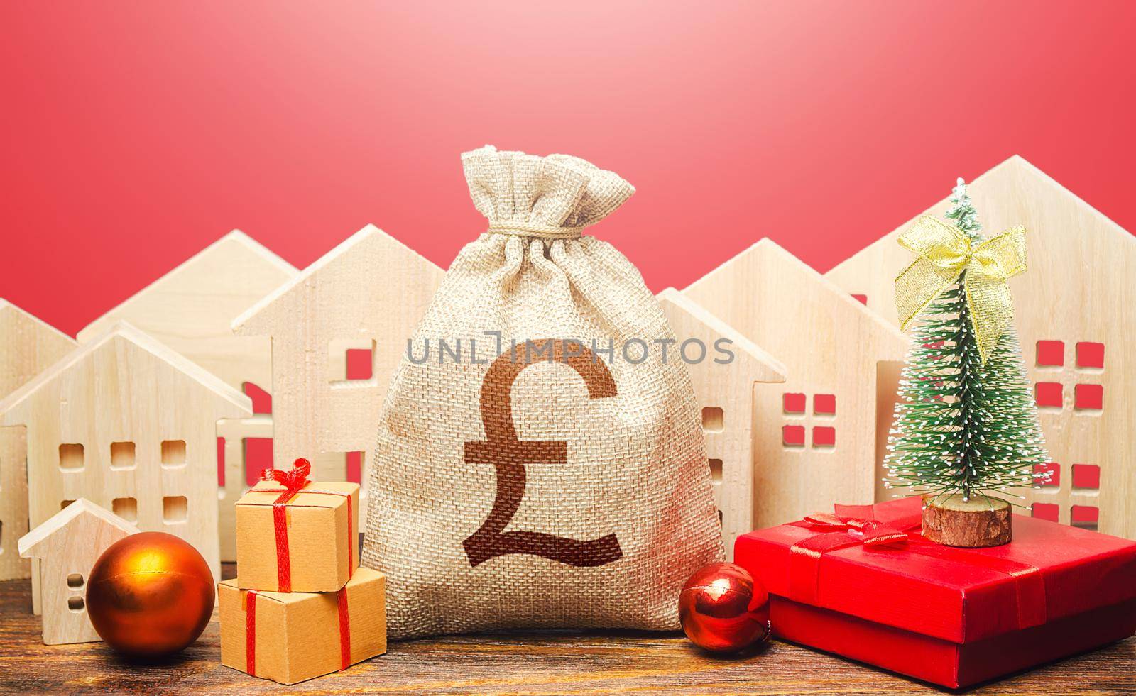 British pound sterling money bag and houses in a New Year's setting. New Year or Xmas winter holiday. Increase in investment attractiveness. Promotions, offers. Mortgage loans. Bank deposit