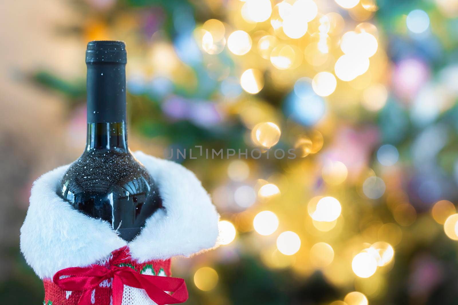 Luxurious holiday composition, a bottle wine with a Christmas tree and bokeh lights on the background with copy space, Holiday concept space for text