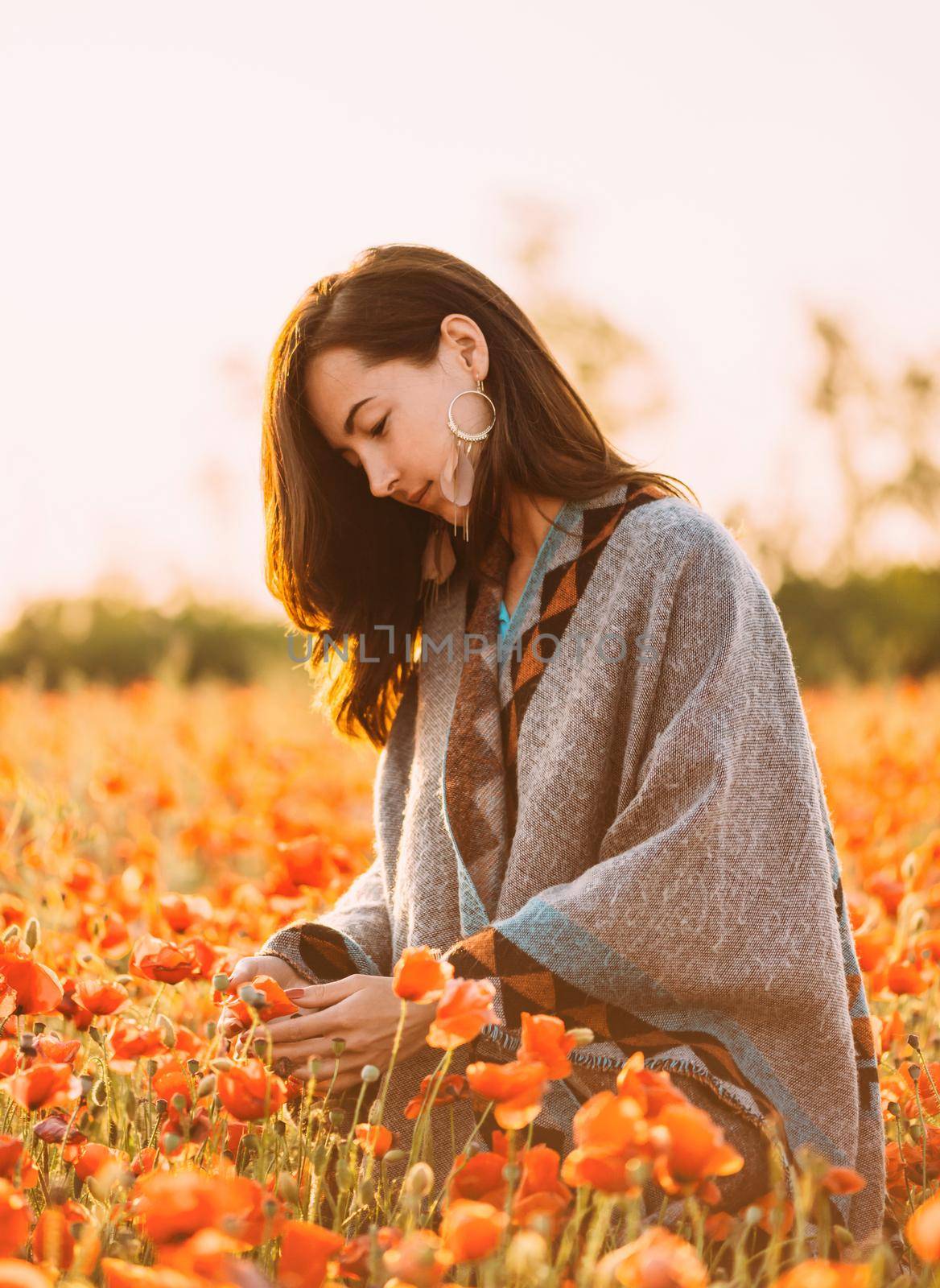 Smiling young woman walking in poppies meadow. by alexAleksei