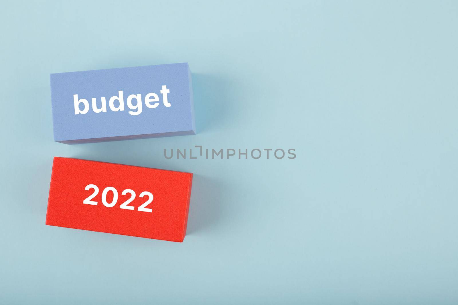 Business plan or budget concept 2022. Text budget 2022 written on red and blue rectangles on bright blue background with copy space by Senorina_Irina