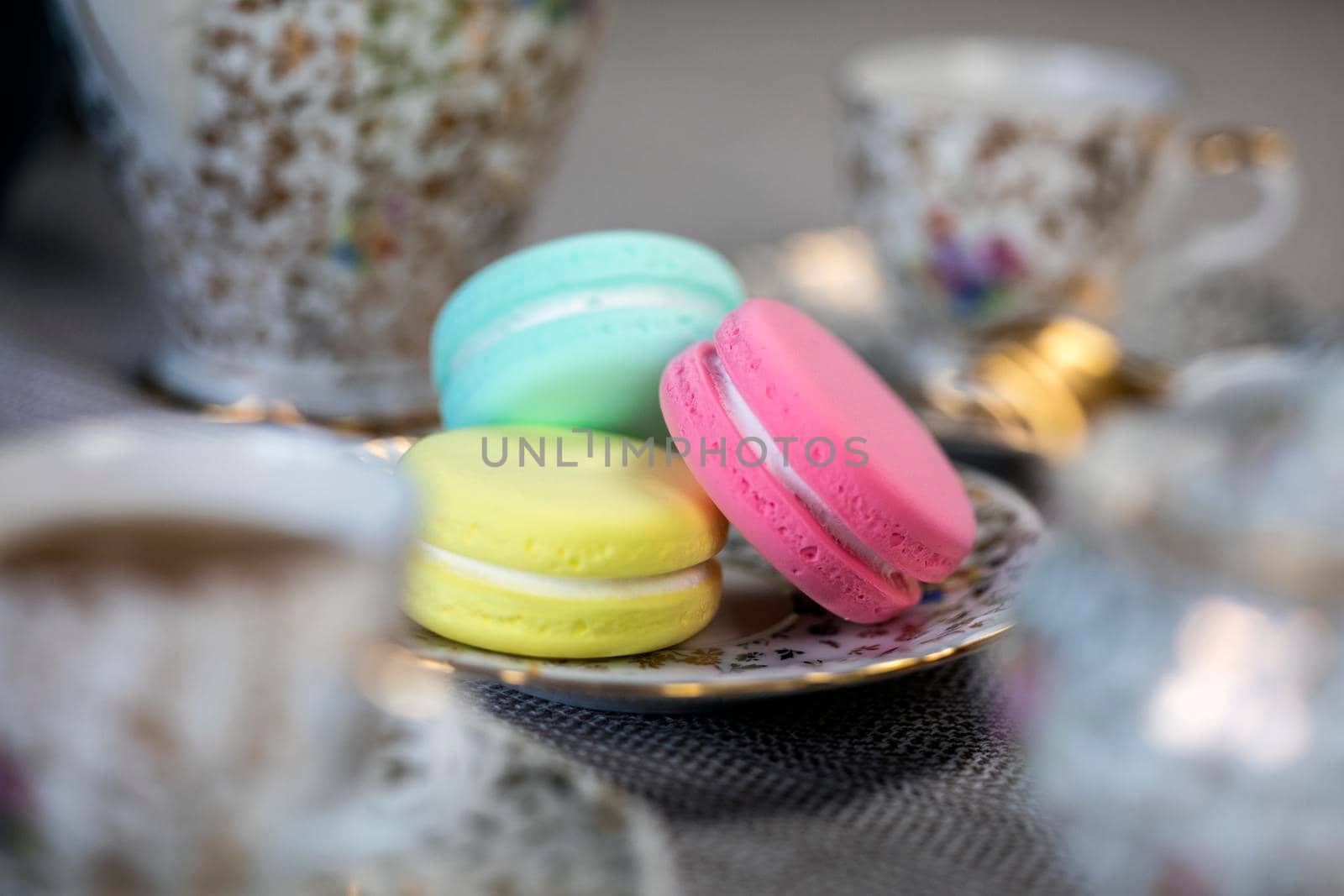 Traditional table with cup of tea and tea pot and colorful macaron lovely cozy table at home,Mother's Day tea setting with teapot, close up