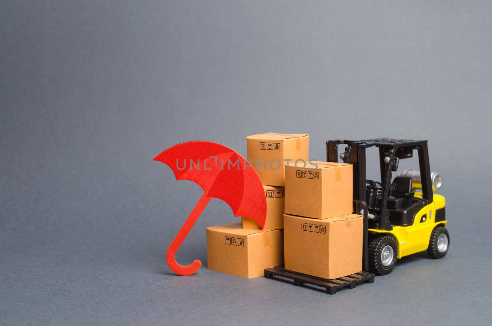 Yellow Forklift truck near carton boxes with a pattern of shopping carts and umbrella. insurance, providing warranty on purchased products. Protection manufacturer. Risk reduction Economic crisis