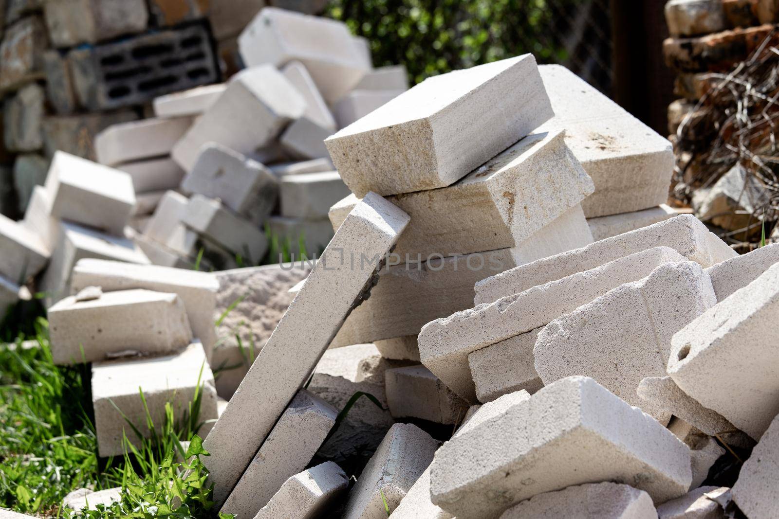 A pile of construction waste is in the yard. White brick or foam block