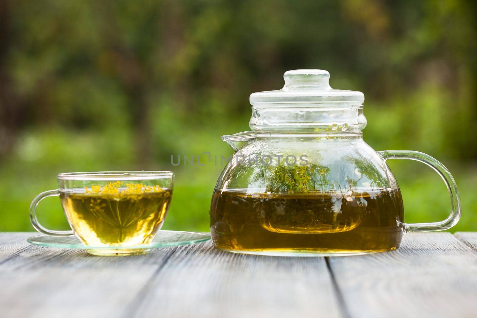 Herbal tea with dill in a glass cup outdoors