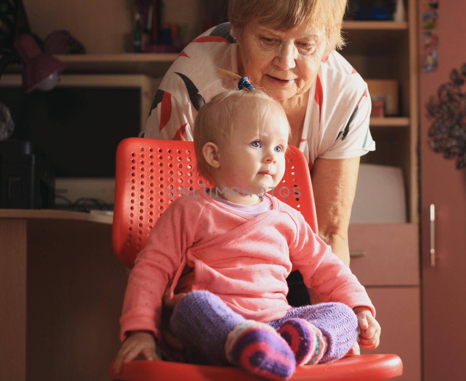 Little sweet girl is playing with grandmother at home by Studia72