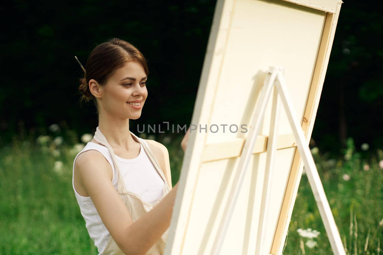 woman artist paints a picture near easel outdoors landscape creative. High quality photo