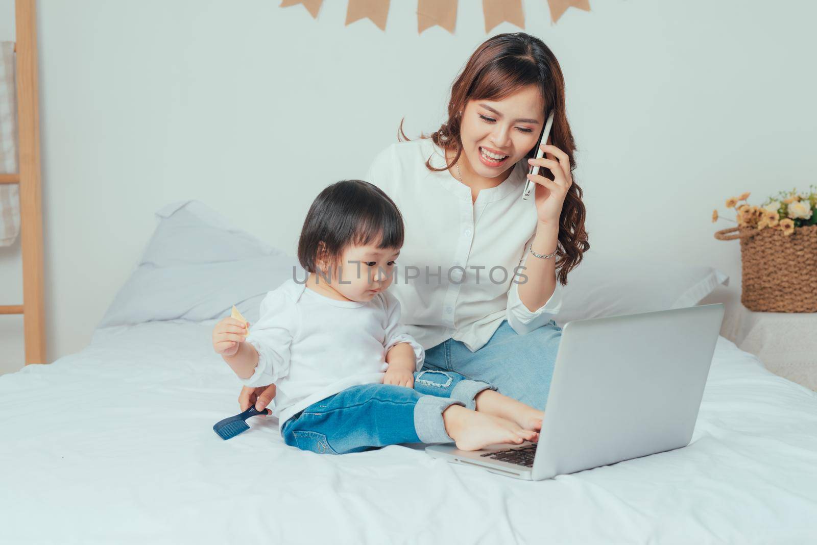 Working mother with her daughter in bedroom at home