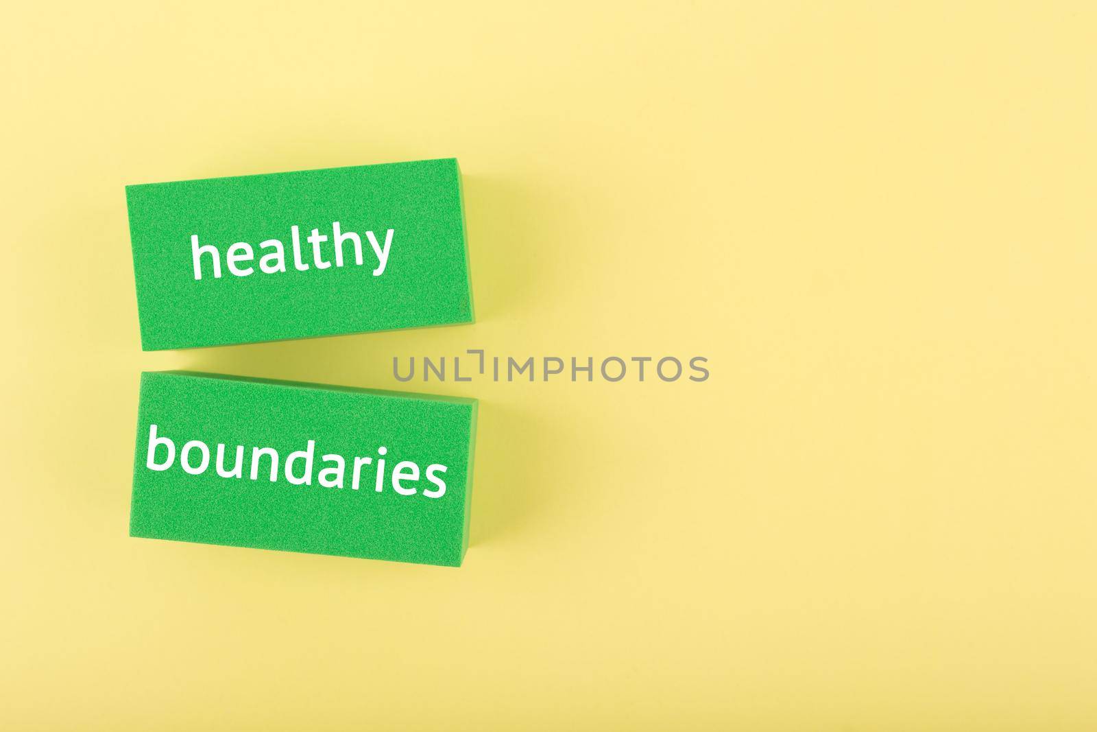 Minimal simple flat lay with green rectangle with written healthy boundaries text on bright yellow background with copy space. Concept of world mental health day, psycology, mental health assessment and awareness