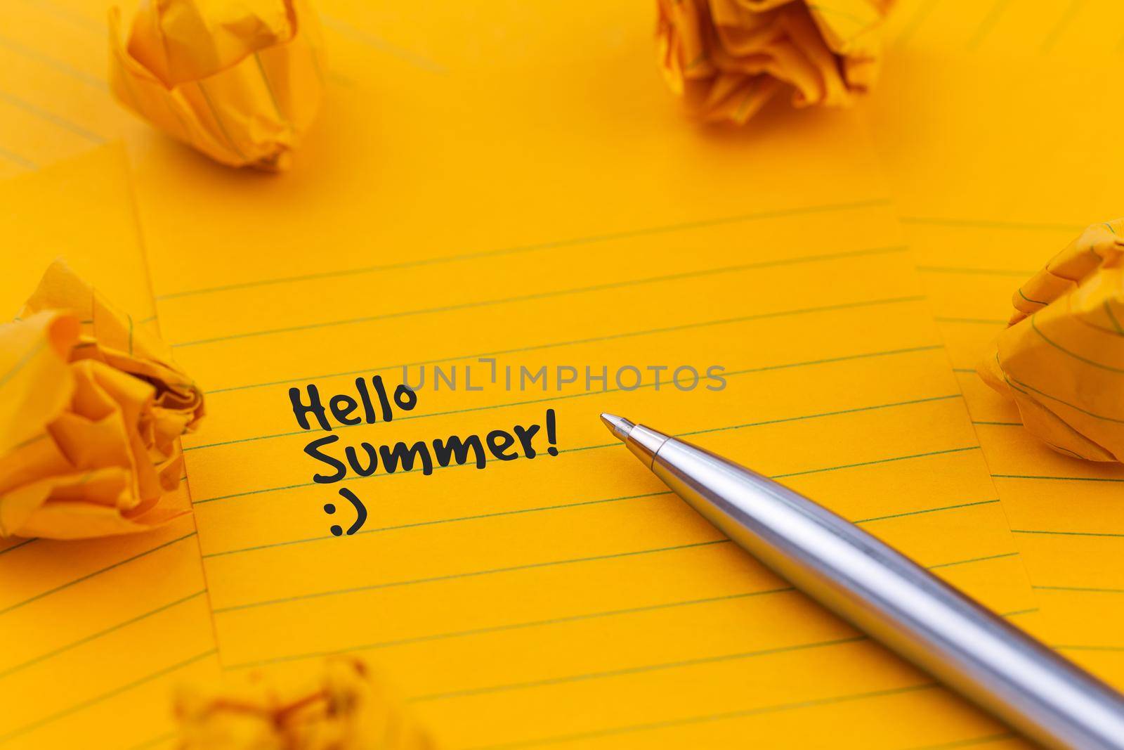 Concept Hello summer or planning a summer trip. Orange sheets of paper, pen and other stationery objects