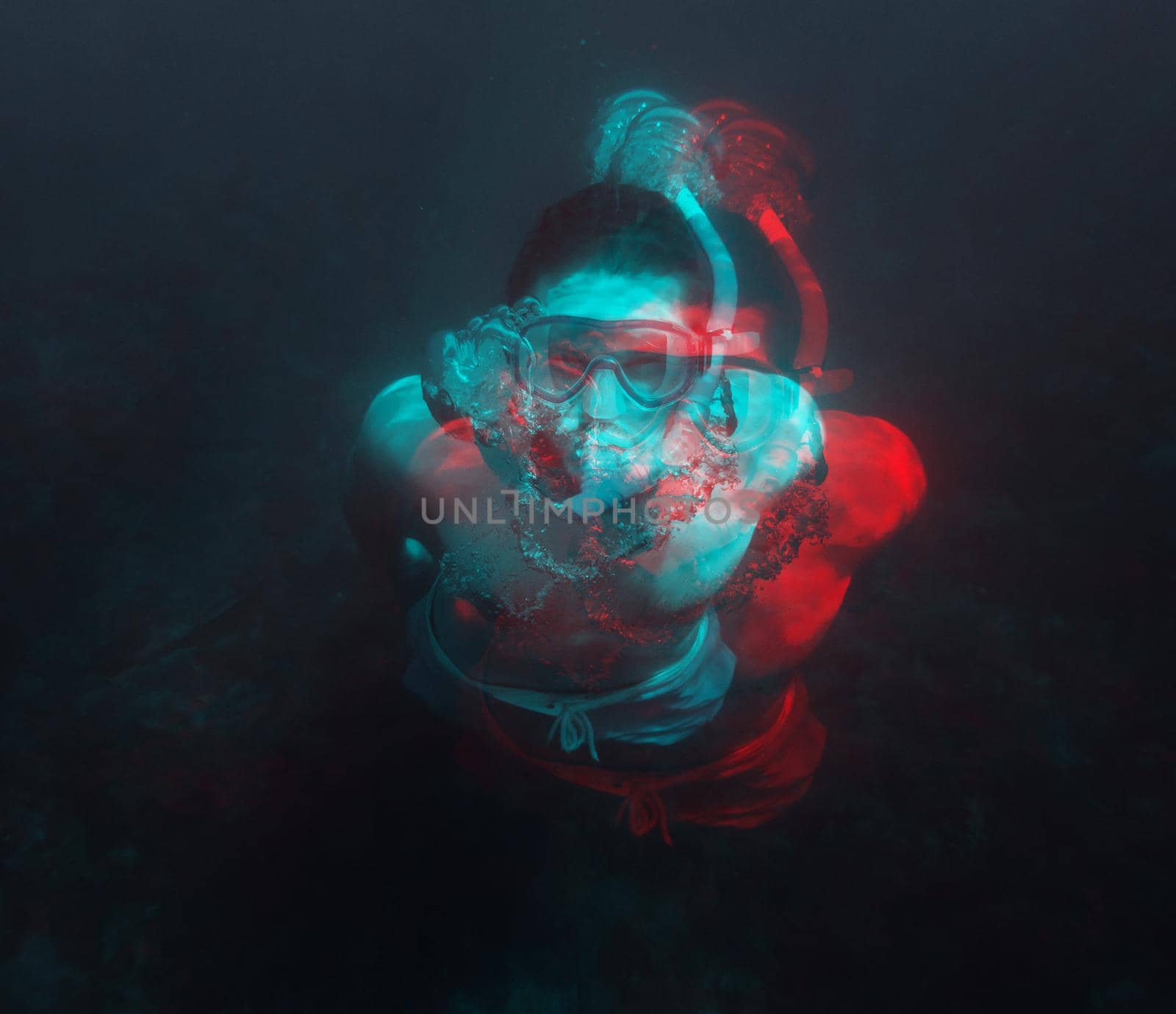 Young man in mask and snorkel swimming underwater in deep sea. Image with anaglyph effect.