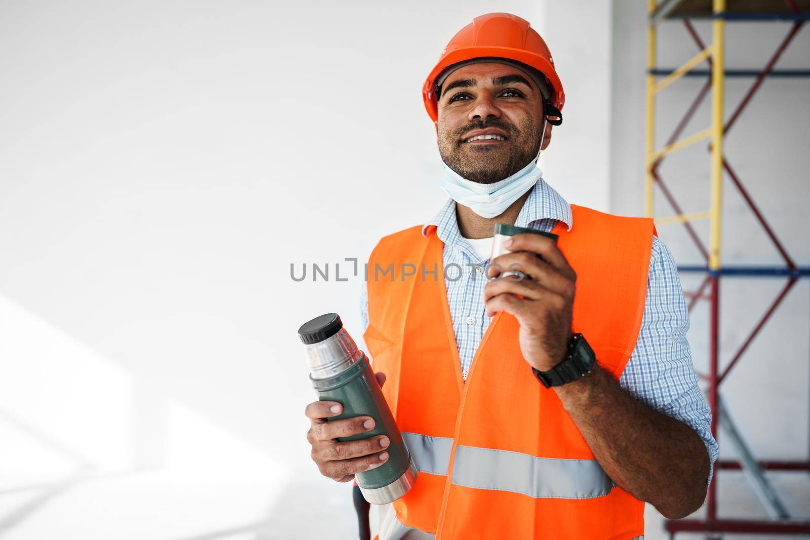 Portrait of a man worker in workwear on a break drink coffee and have rest, close up