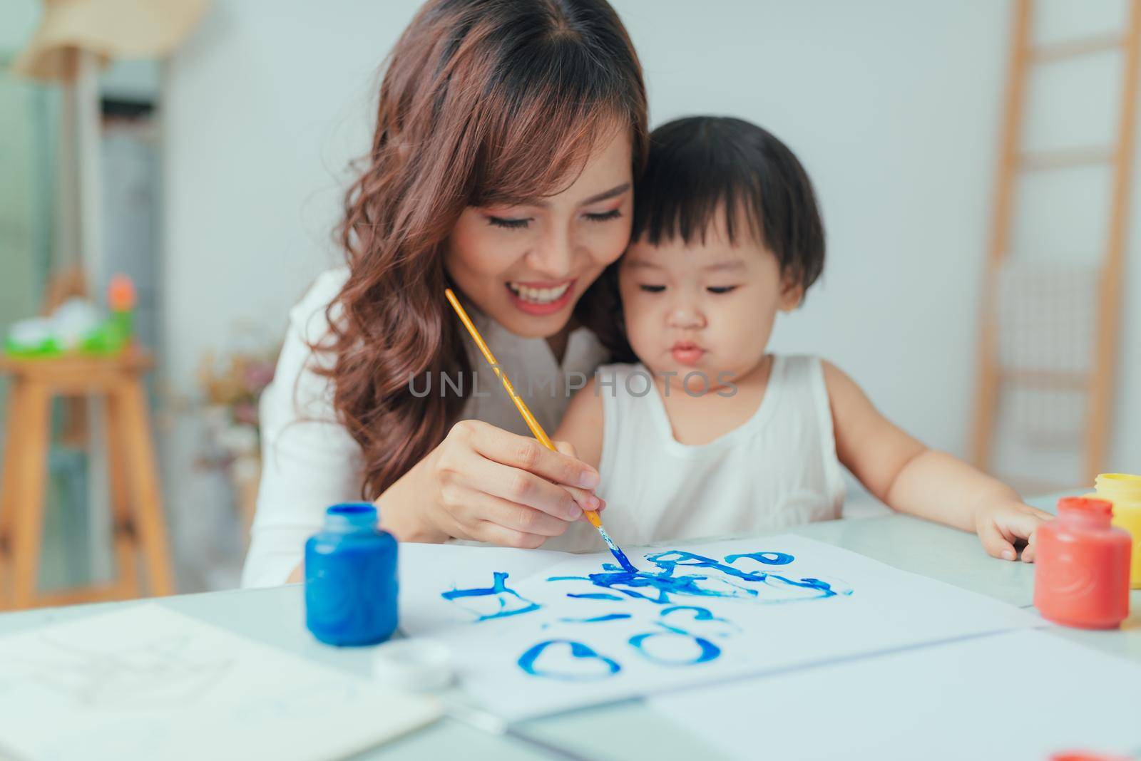 Portrait of asian woman and her daughter painting together