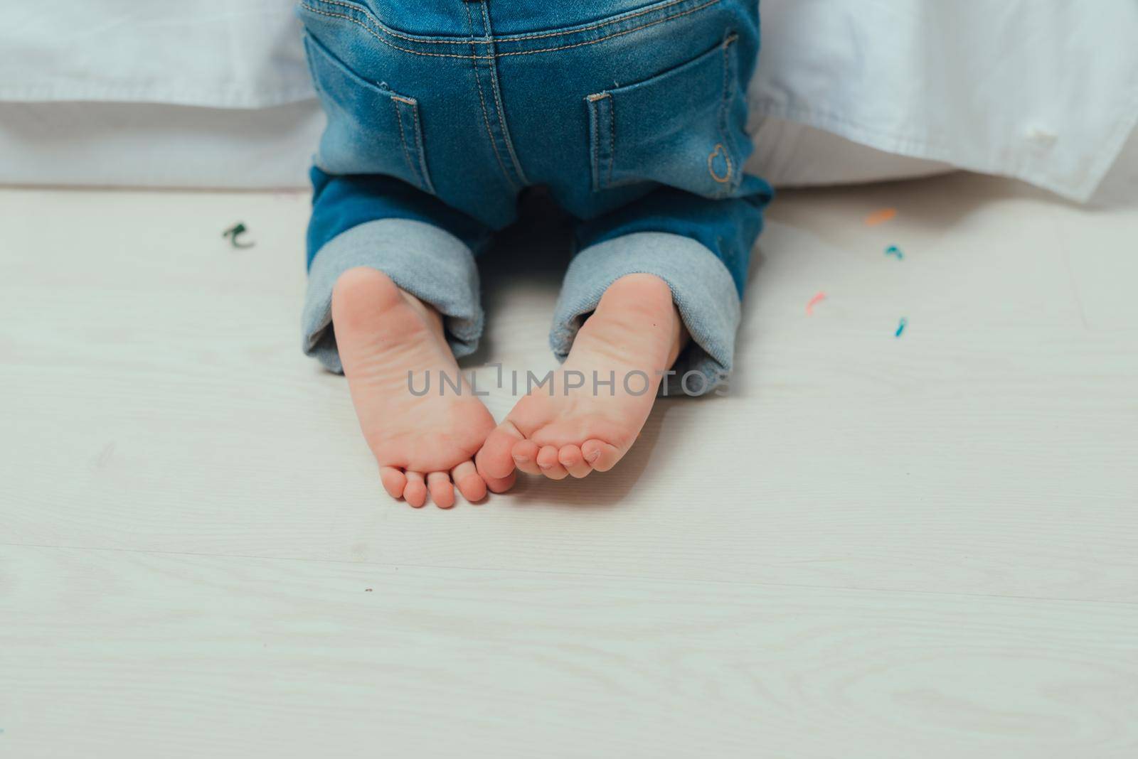 Children's bare feet. Child's bare feet on the wooden floor by makidotvn