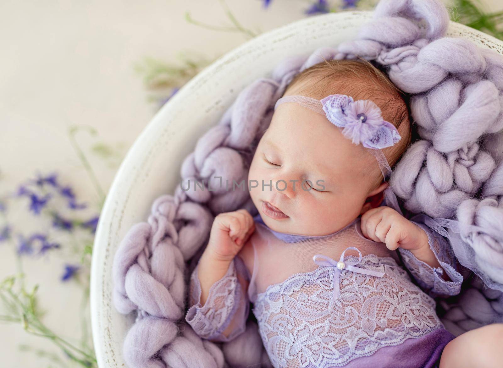 Sleeping newborn baby girl in a pink dress