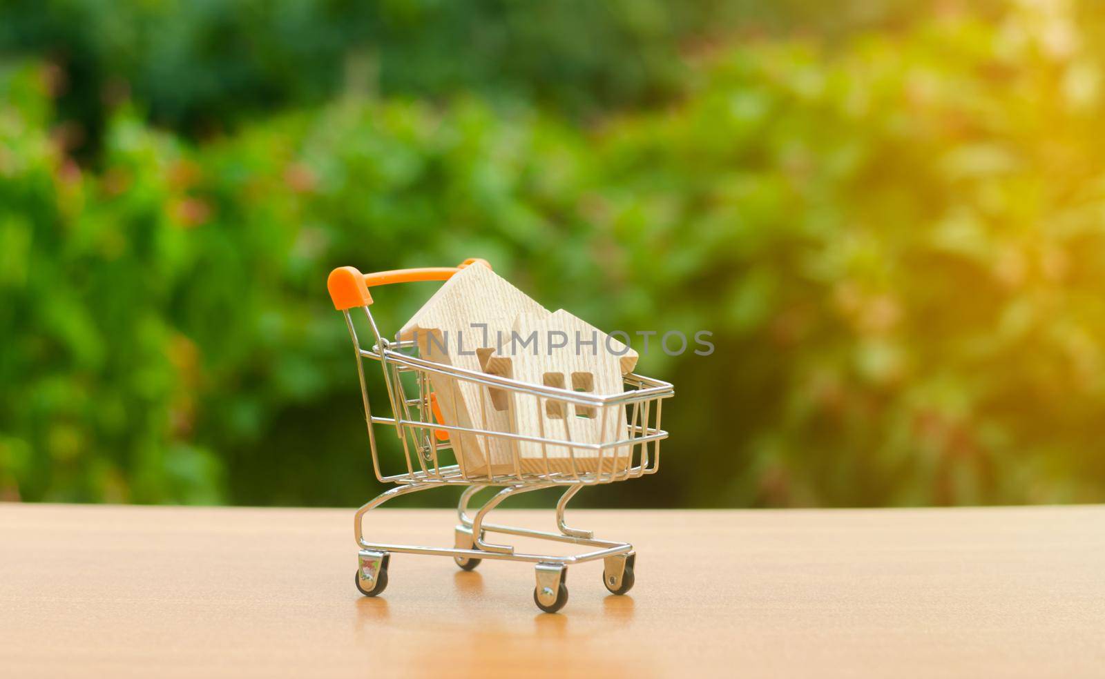 Two wooden houses in a trading cart on nature background. Attractive investing. rising prices. supply and demand, rates of sales. The concept of buying and selling real estate, renting.