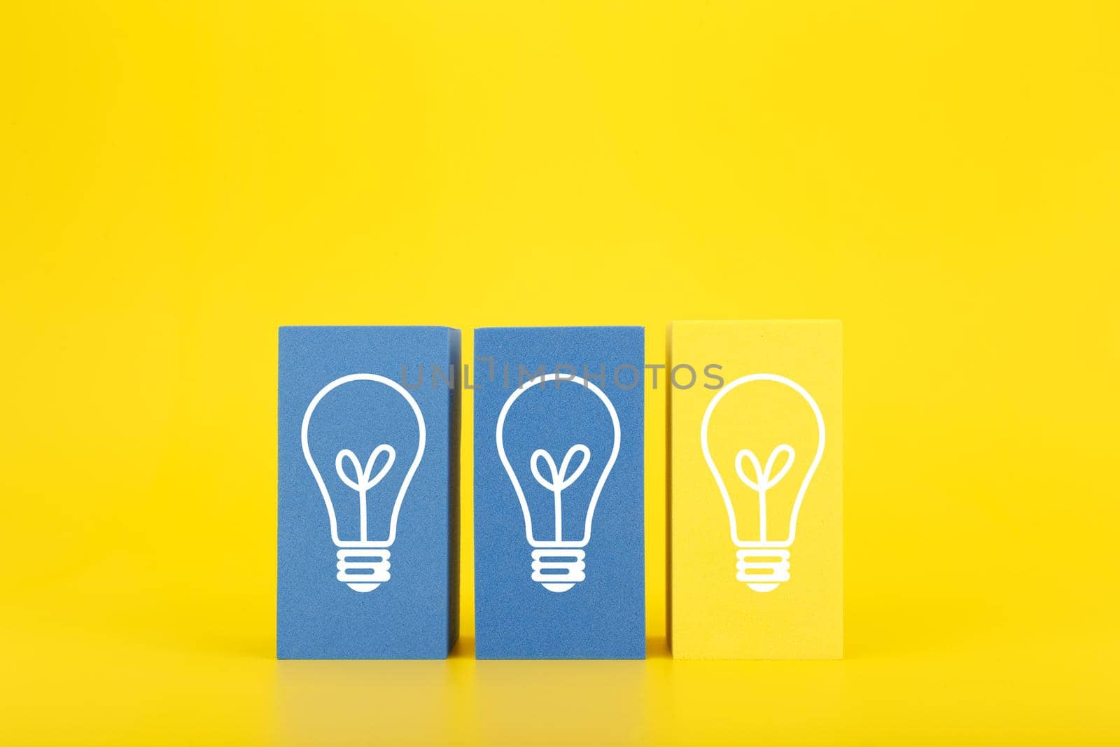 Concept of idea, creativity, start up or brainstorming. White drawn bulbs on blue and yellow rectangles in a row against bright yellow background