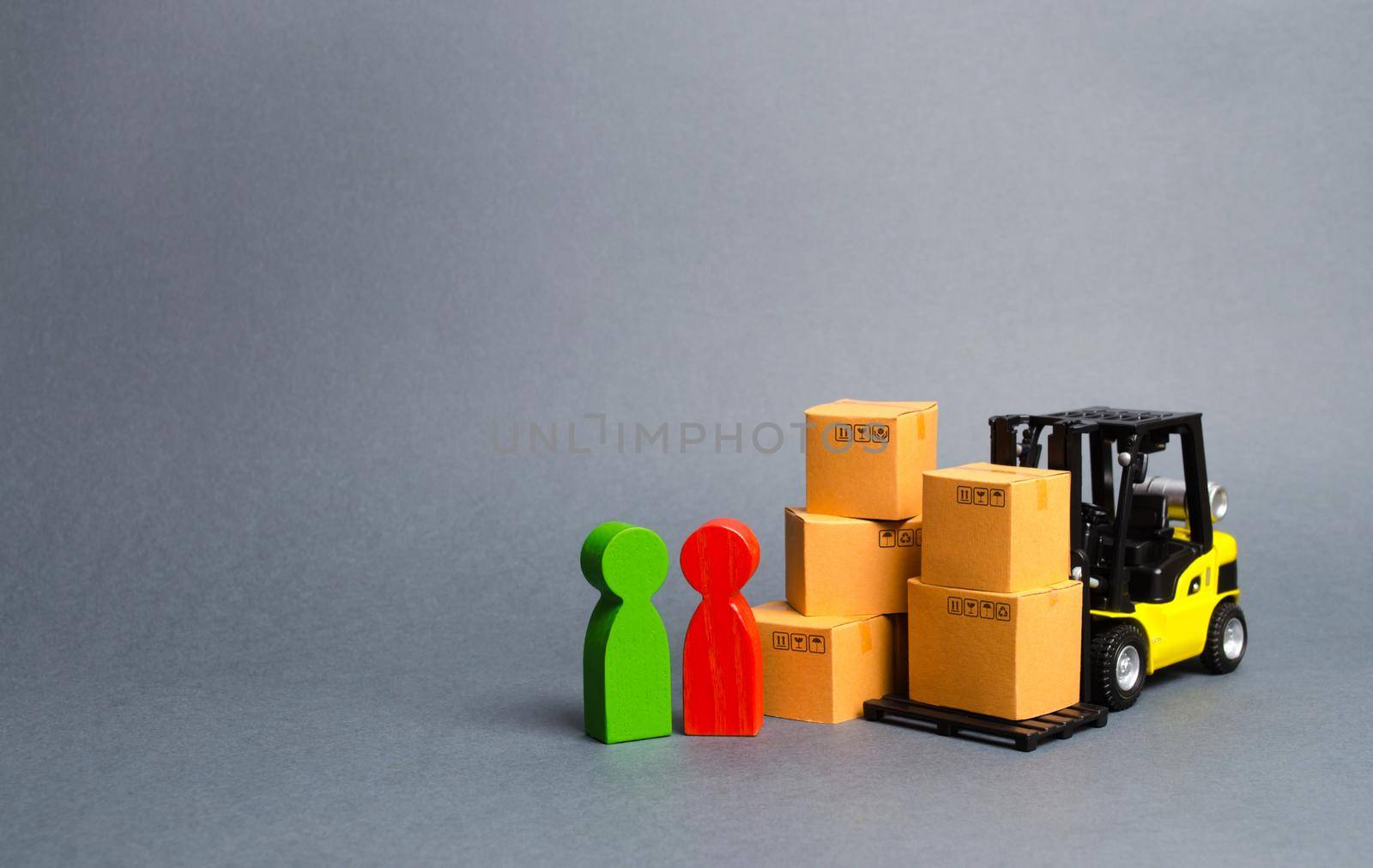 Yellow Forklift truck with cardboard boxes near a customer buyer and seller. Business and commerce. Negotiations on supply of goods. The organization of the supply of outlets goods. Trading networks