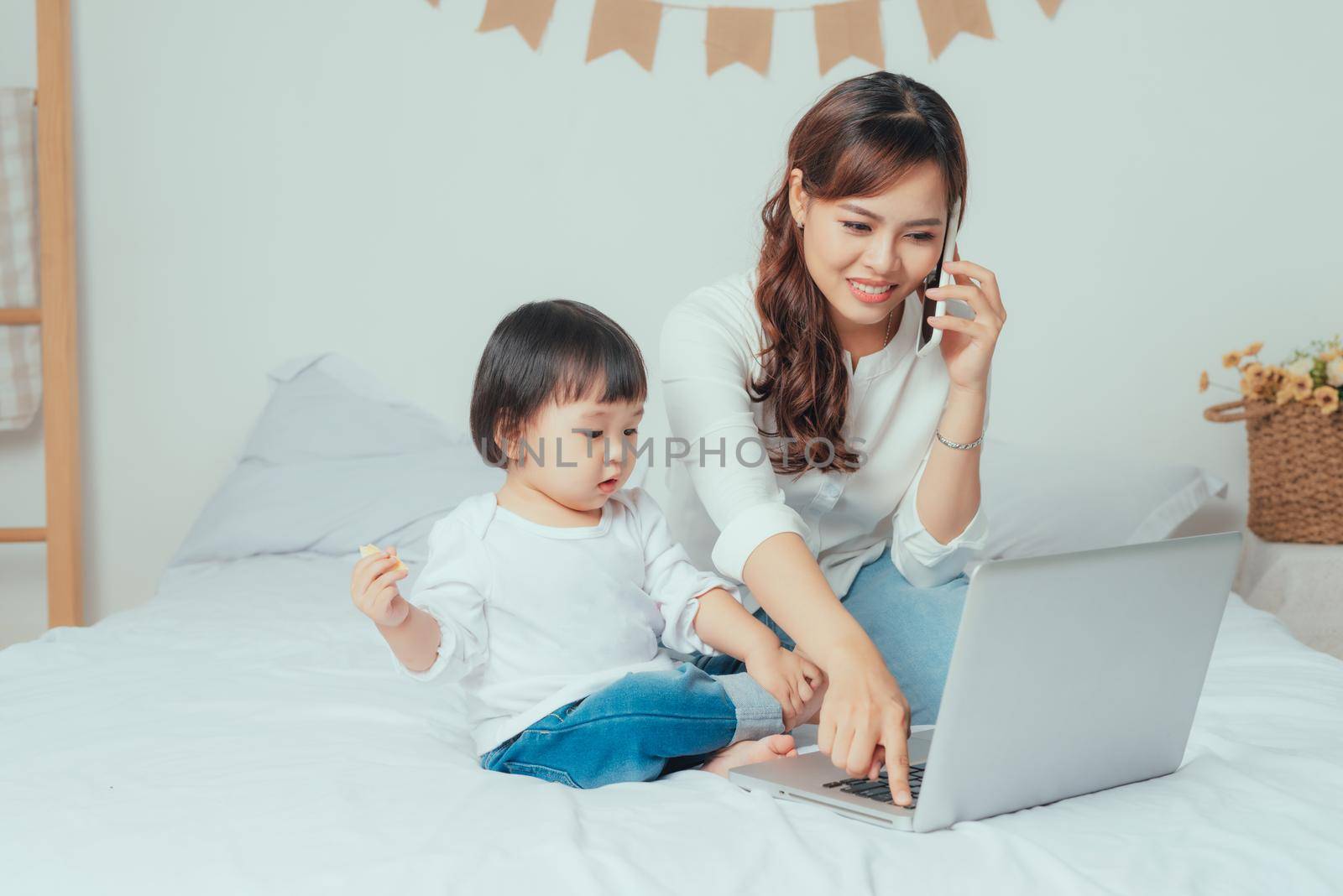 Young mother working from home with daughter