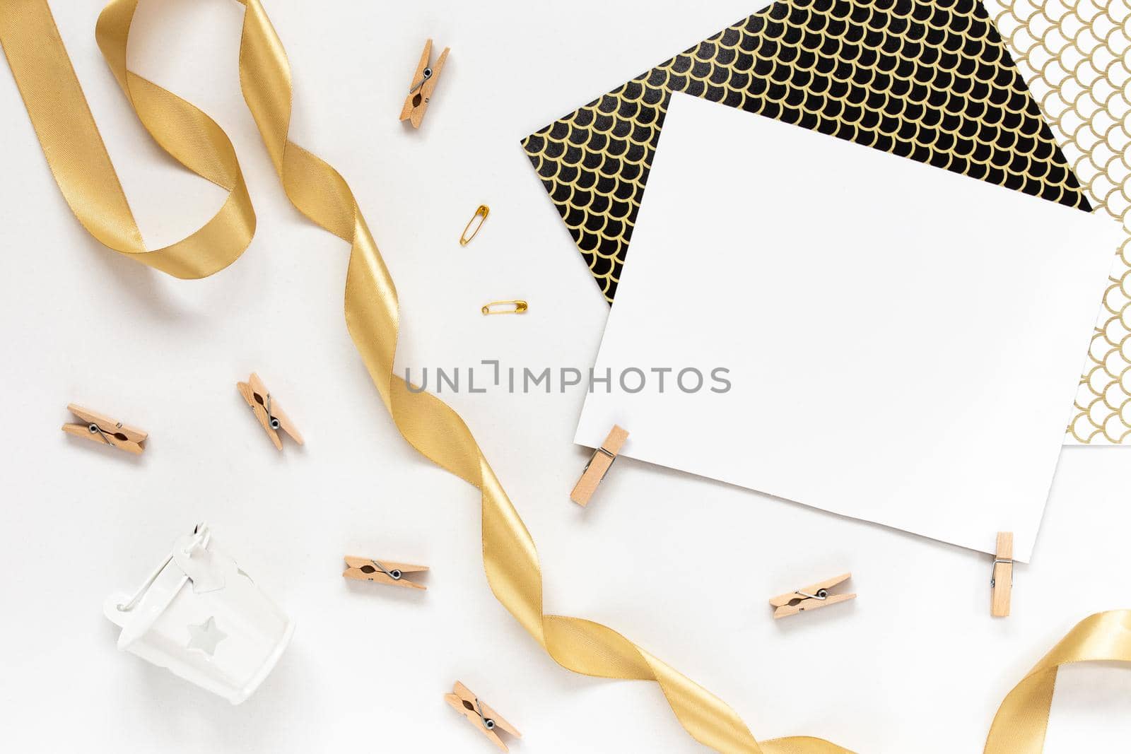 Top view on Beautiful greeting card idea with area for your text with golden ribbon, wooden clothespins copyspace, topview, mockup, flatlay.