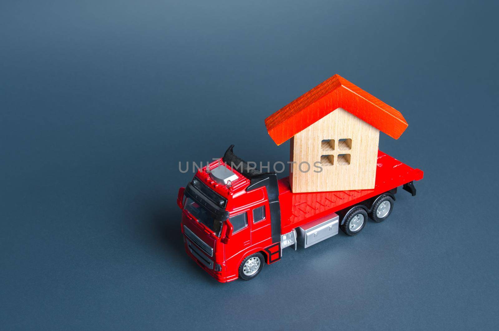 Truck transporting a house. Delivery services to another house. A moving company. Transportation of real estate. Resettlement program for new housing. Construction industry. Building insurance.