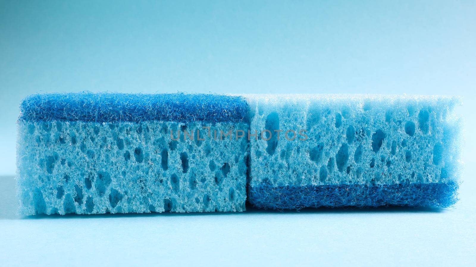 Two blue sponges used for washing and erasing dirt used by housewives in everyday life. They are made of porous material such as foam. Detergent retention, which allows you to spend it economically.