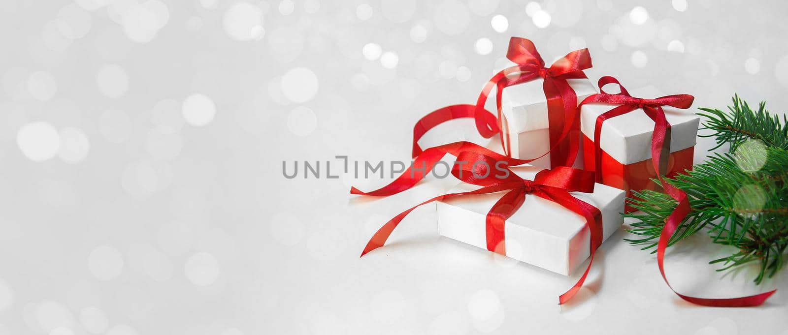 Christmas Gift's in White Box with Red Ribbon on Light Background. New Year Holiday Composition Banner. Copy Space For Your Text