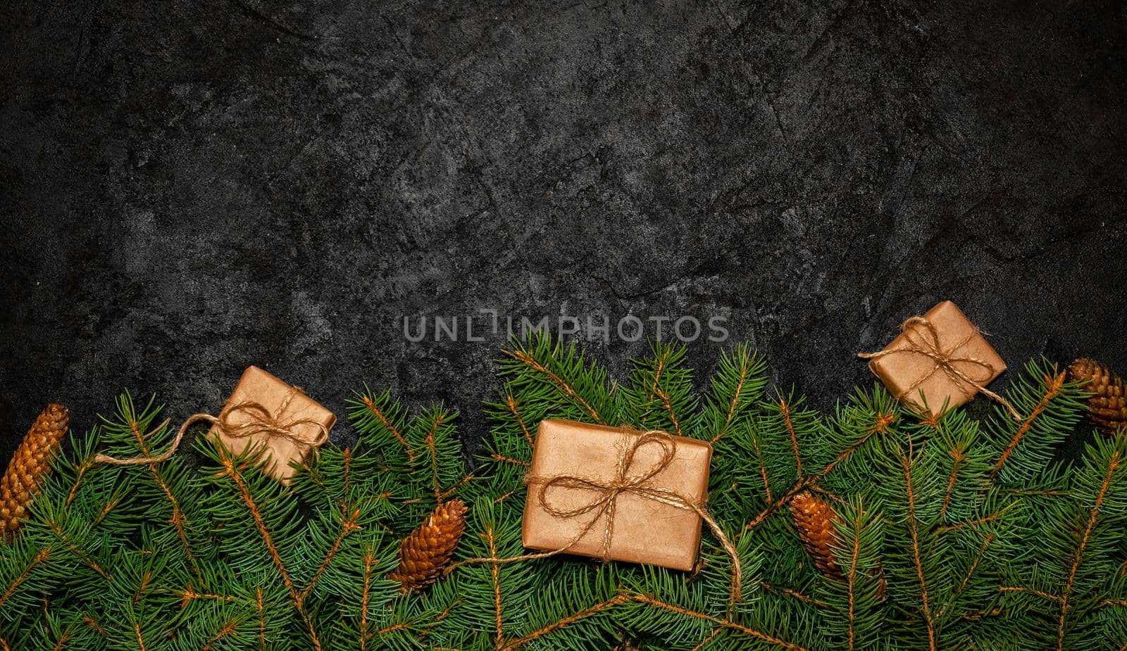 Minimal Holiday Composition From Green Fir Branches with Small Gift Boxes on Dark Background. Creative Nature Concept. Flat Lay. Copy Space For Your Text by Svetlana_Belozerova