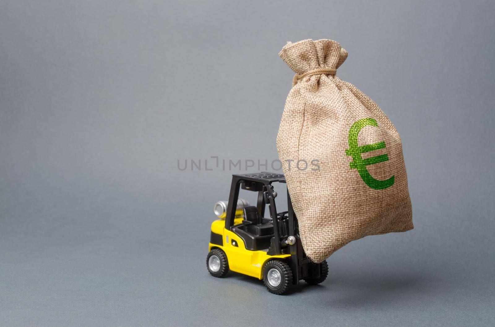 Yellow forklift truck carries a big bag of money. Attracting investment in development, modernization of production and business. Revenue, profit, liquidity. profit point fixation. capital migration
