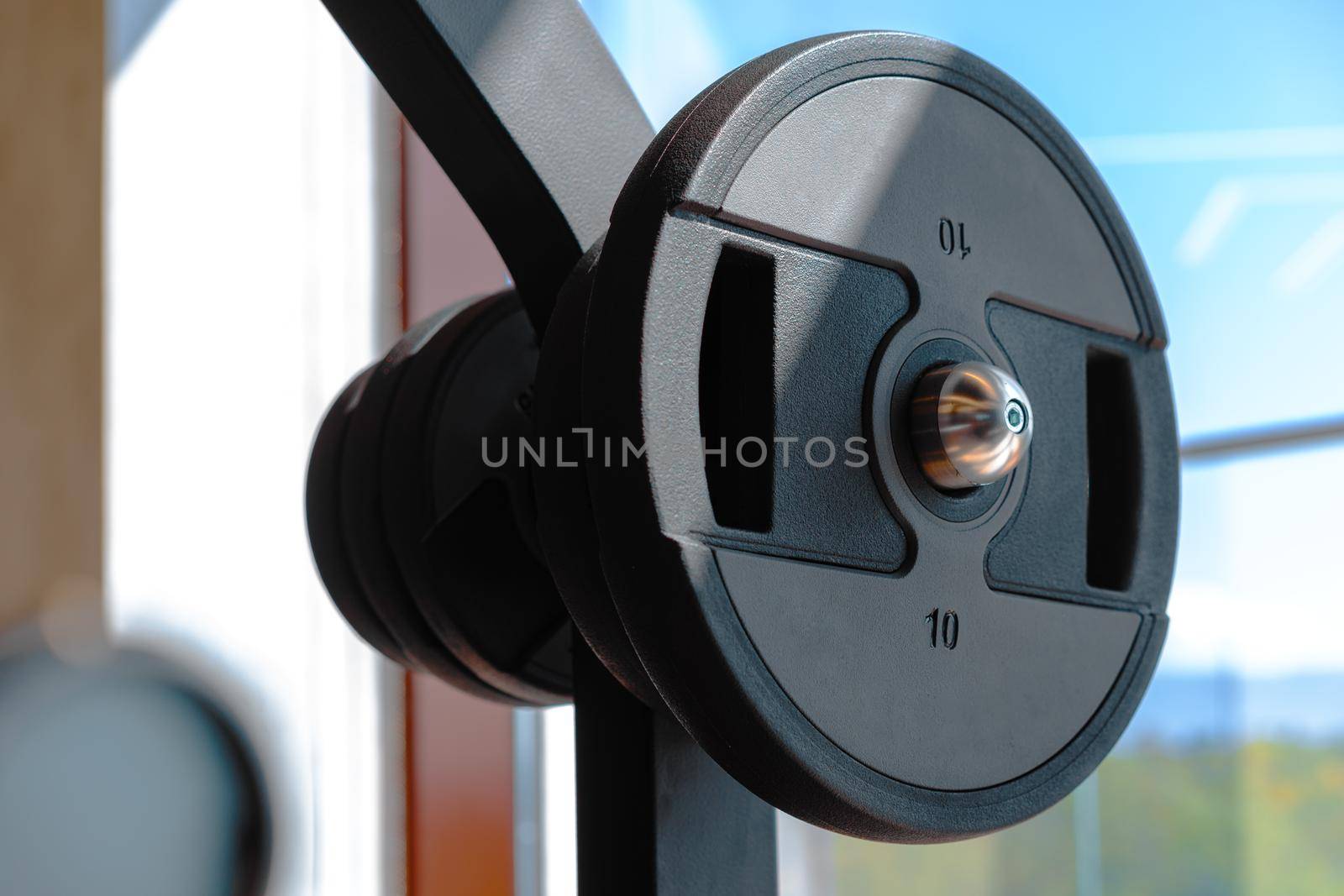 Weight plate on metal barbell in a gym, close up