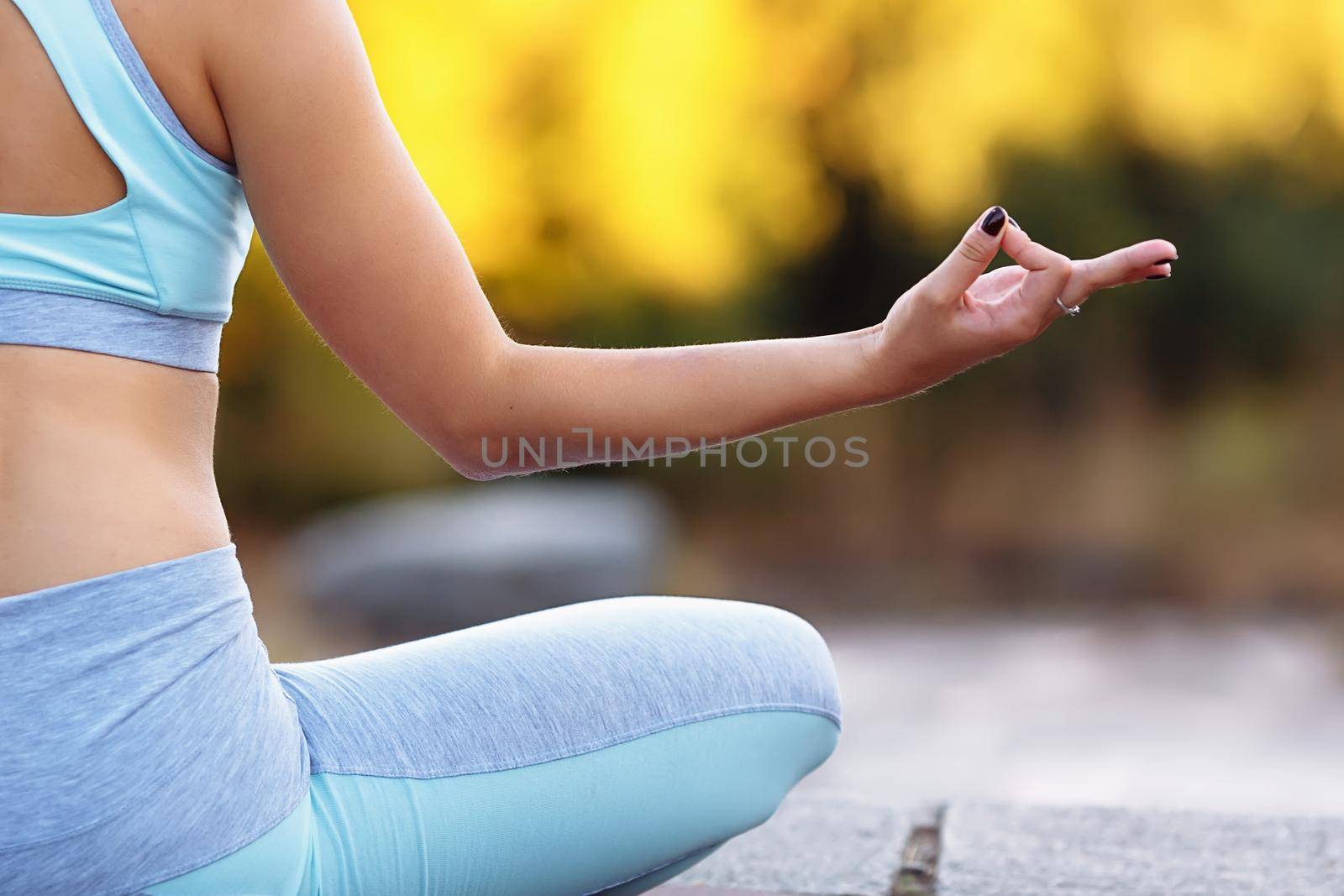 Close up of hand of young man sitting in lotus pose indoor. Light, zen and home yoga exercising concept with copyspace. Healthy lifestyle concept.