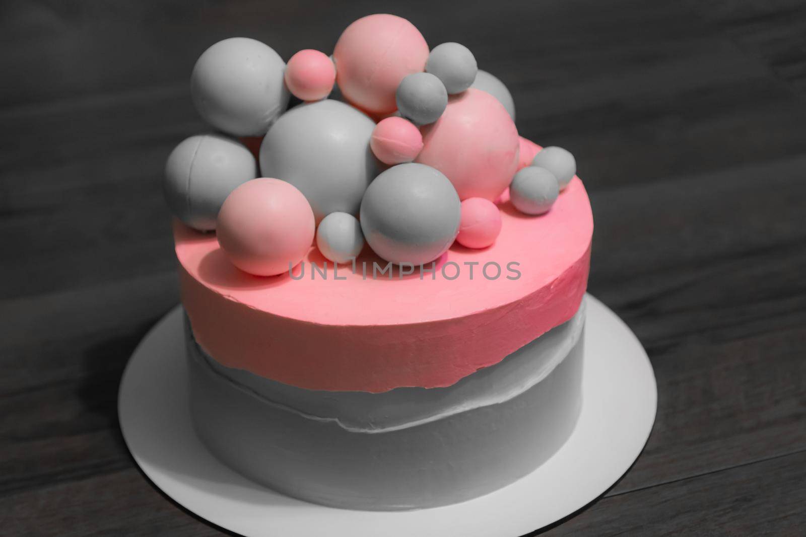 Wedding cake with pink elements made from pastry mastic on a gray background. Sugar balls beautiful decor for decorating cakes. For a menu or a confectionery catalog
