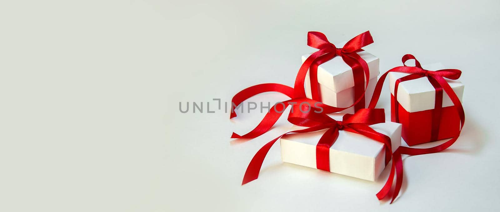 Christmas Gift's in White Box with Red Ribbon on Light Background. New Year Holiday Composition Banner. Copy Space For Your Text by Svetlana_Belozerova