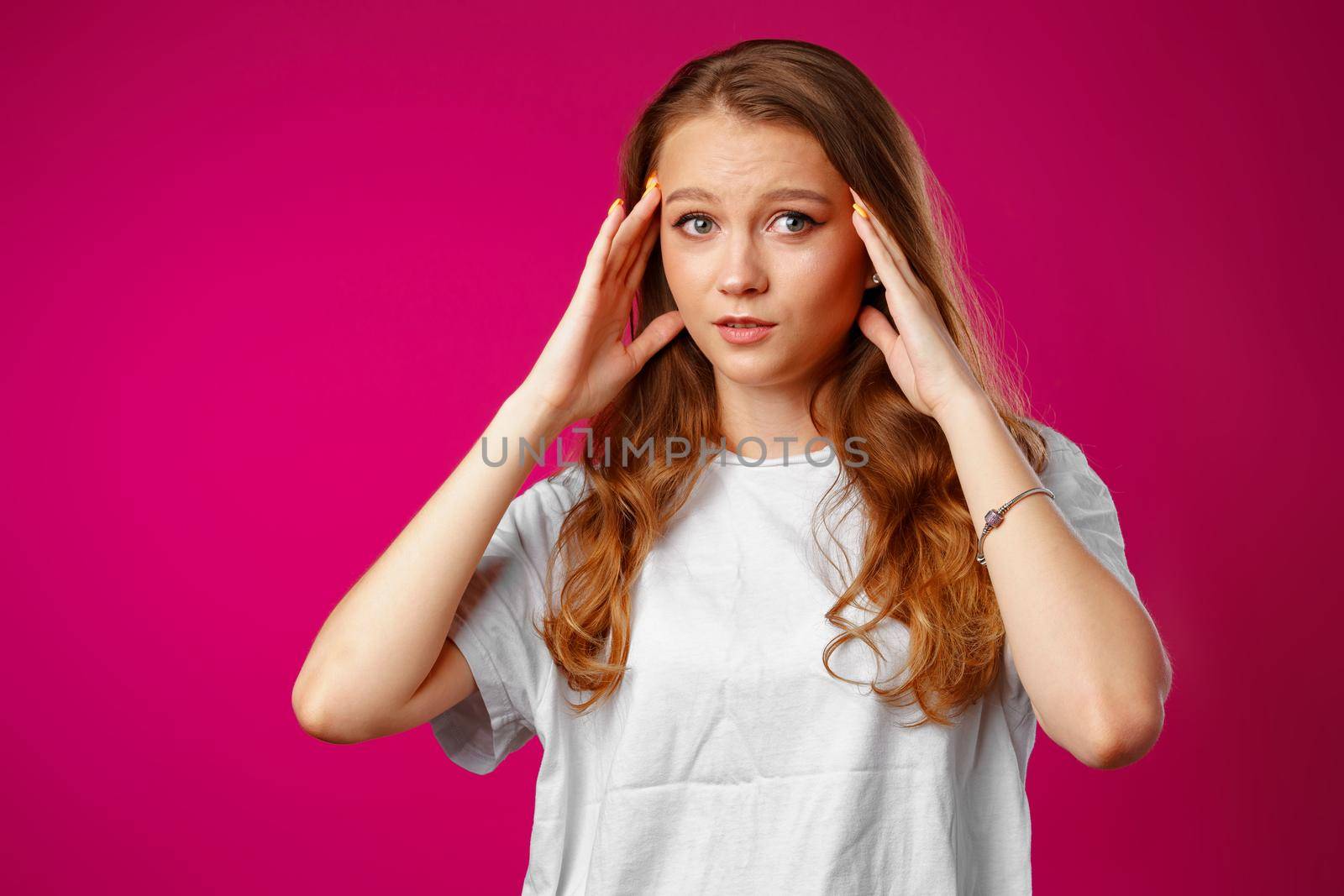 Young beautiful woman suffering from headache with hands on head close up