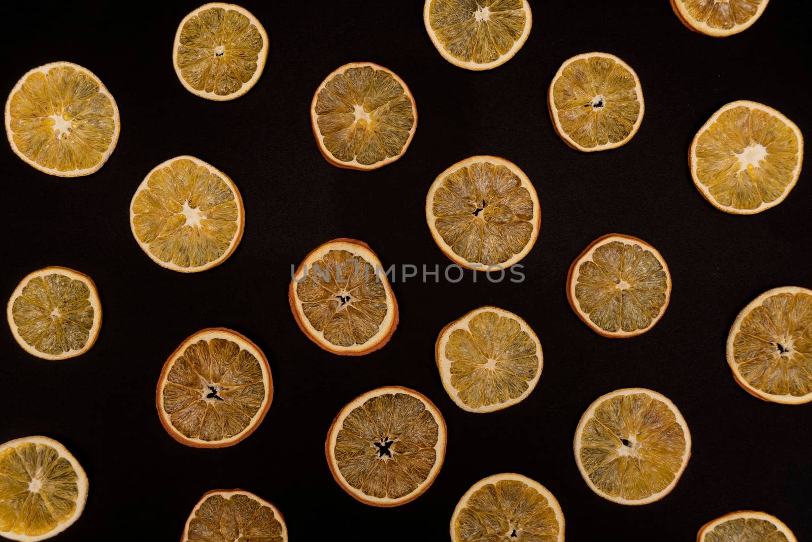 Repetitive pattern of dried oranges and tangerines at black background. by uveita