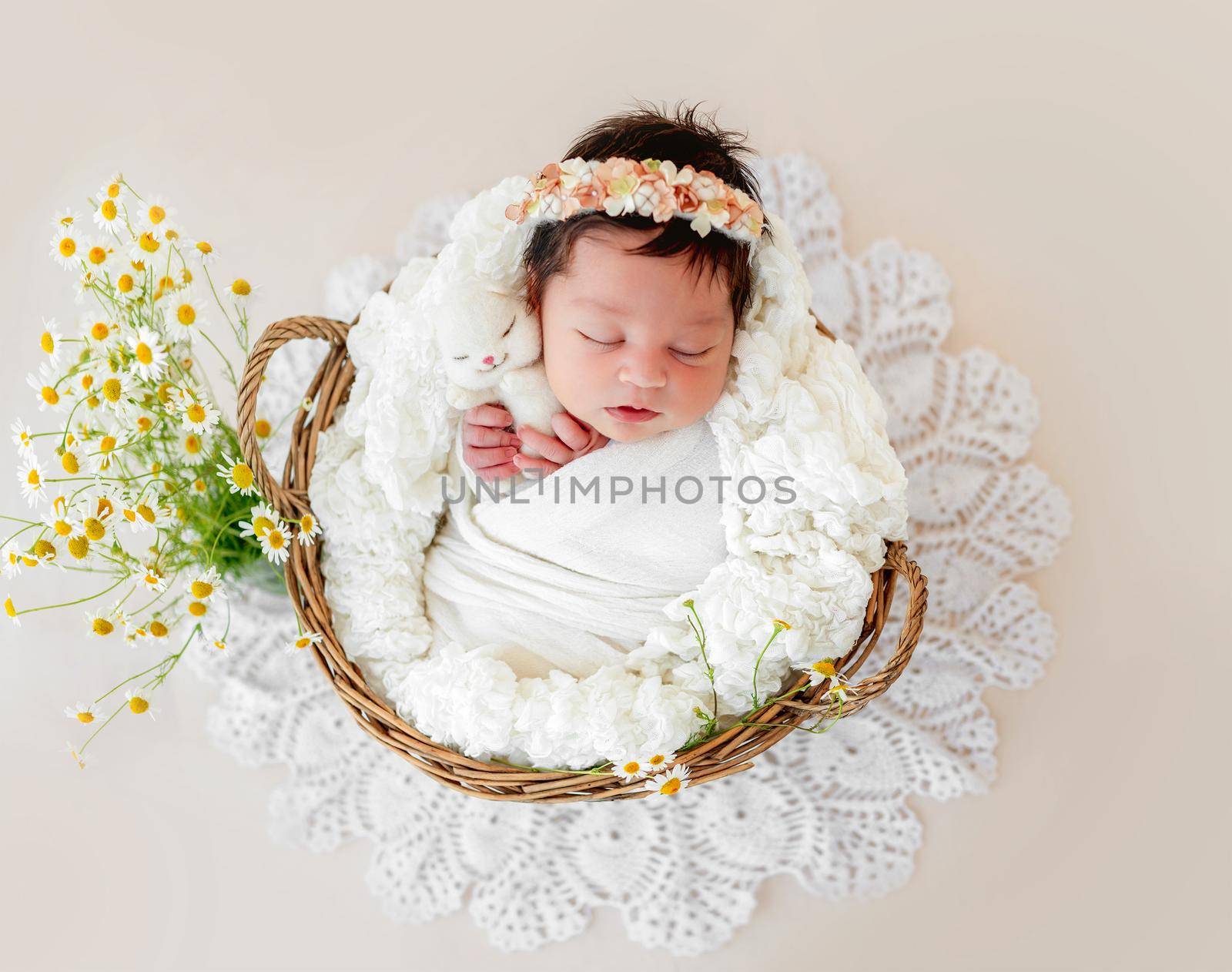 Adorable newborn sleeping in basket with toy