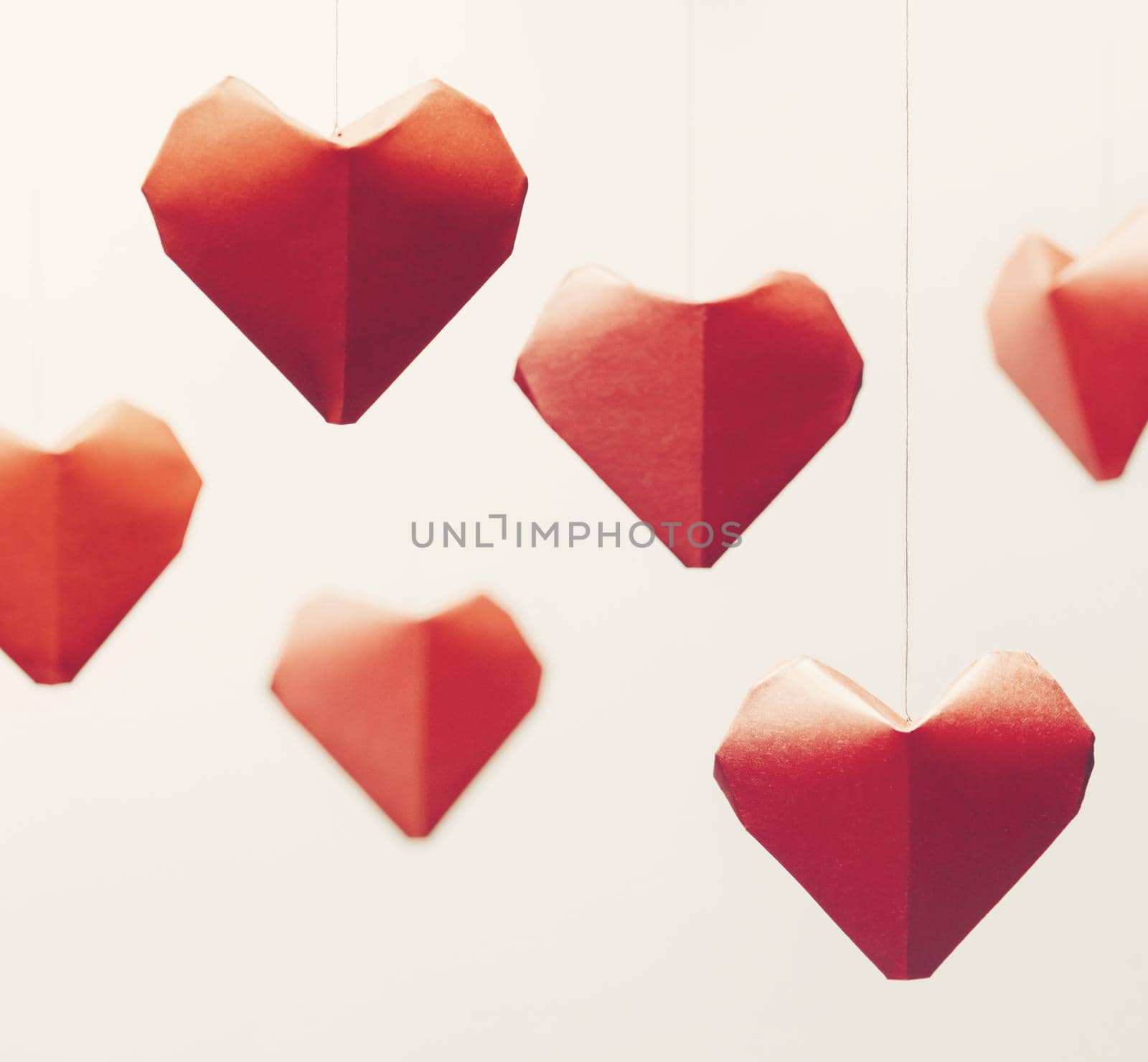 Many red paper origami hearts, symbol of love, on white background. Greeting card on Valentines day.