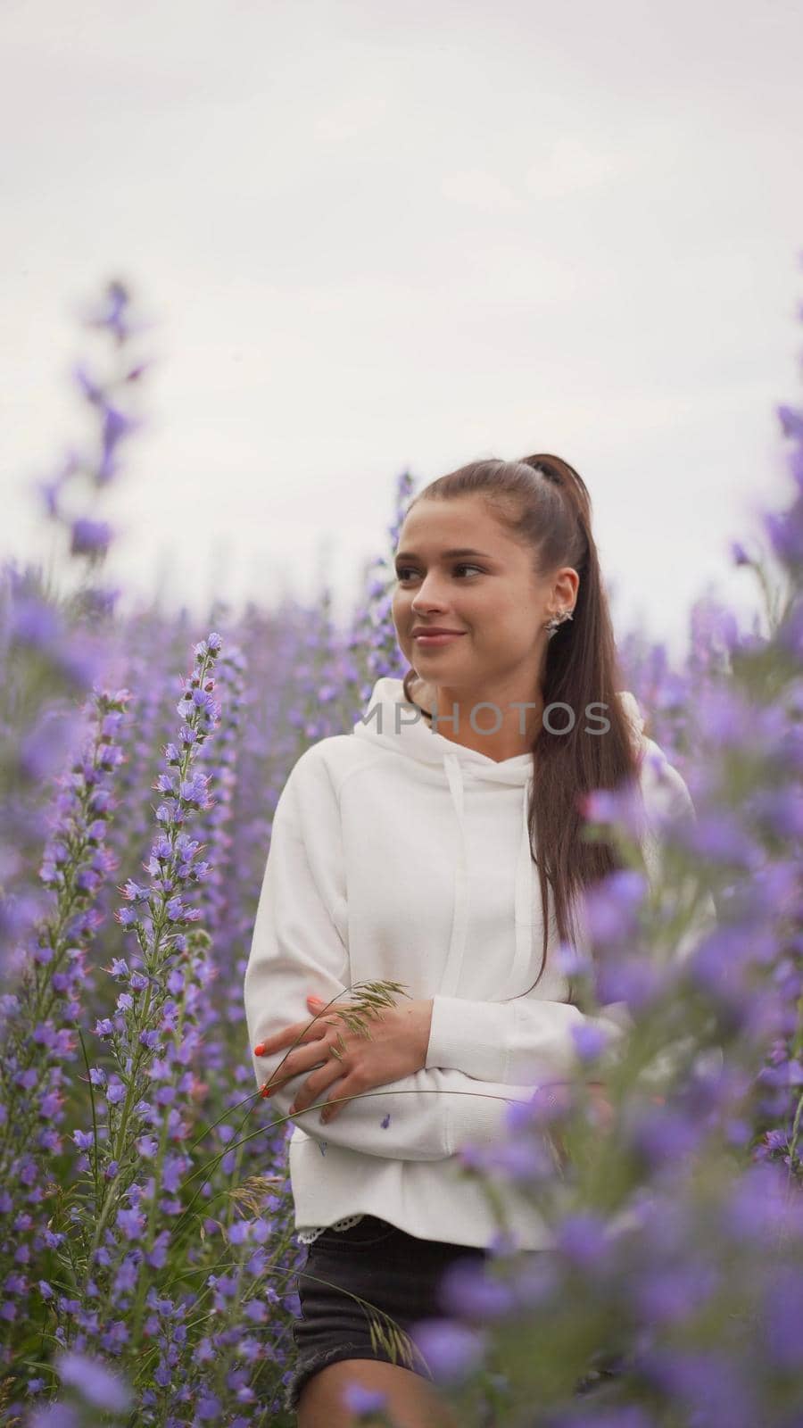 smiling beautiful brunette in the lavender field. Beautiful girl in flowers on a meadow. by Rusrussid