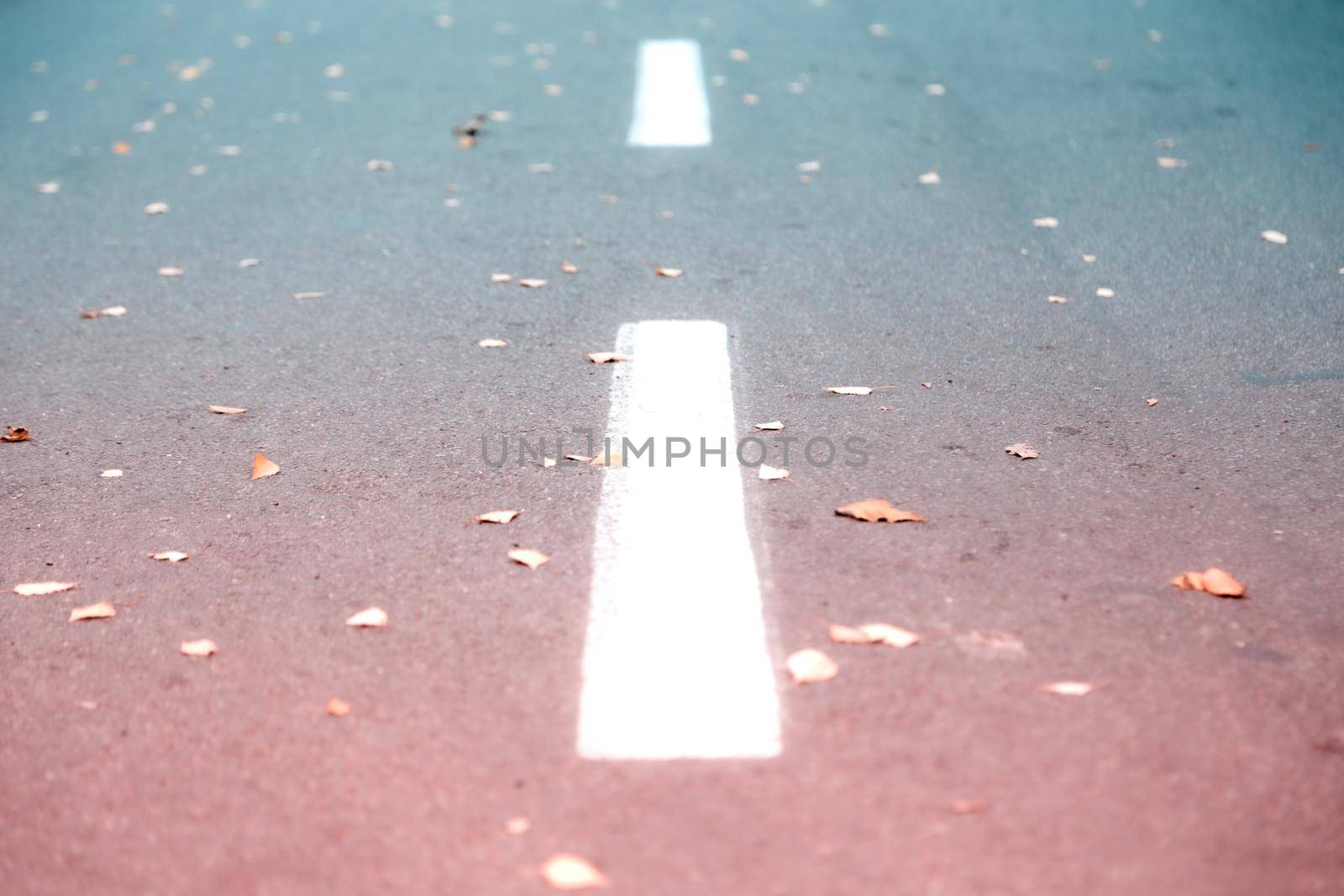 White road strip marking on asphalt. Background and texture with teal and orange color.
