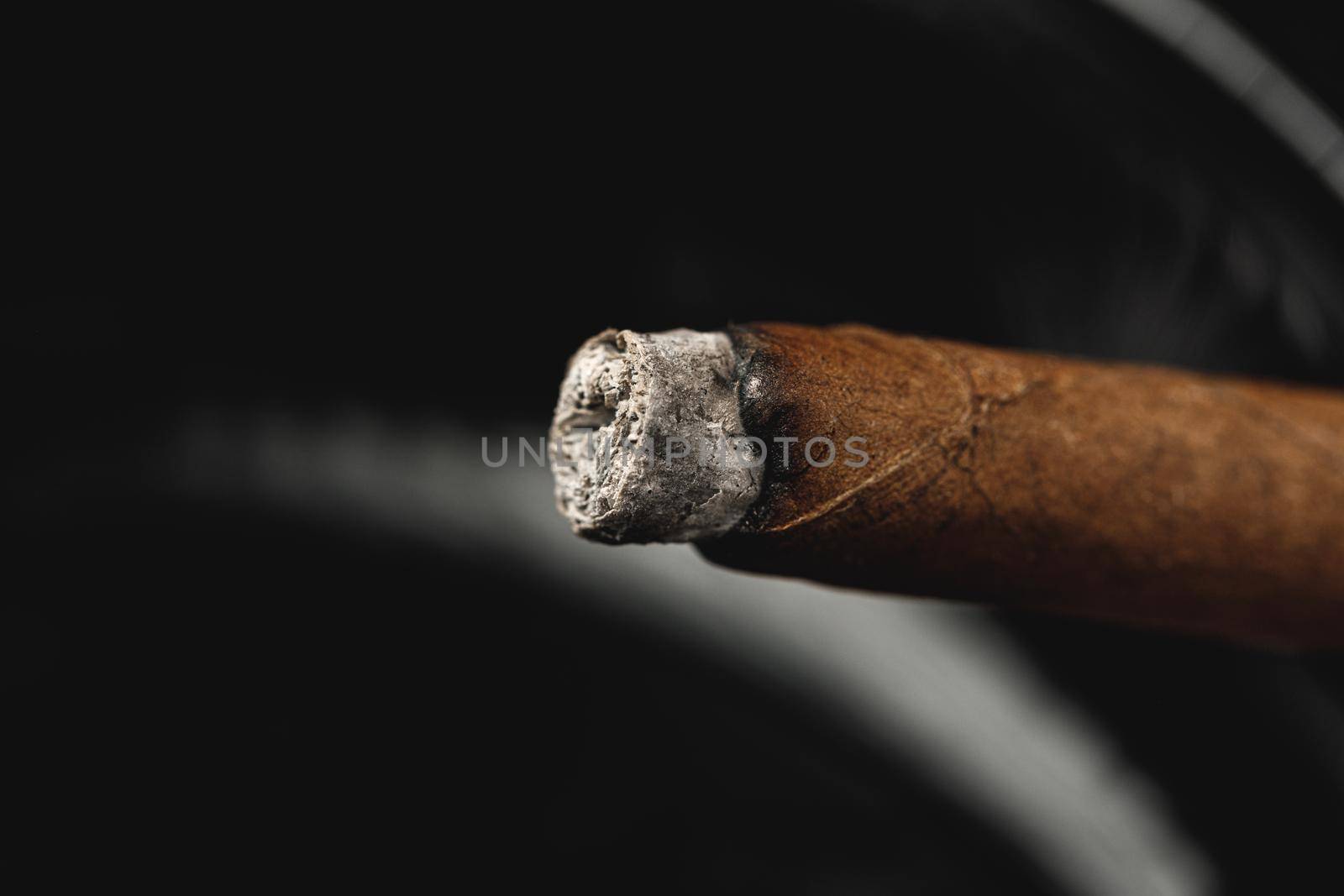 Lighted cigar in an ashtray close up. Smoking concept