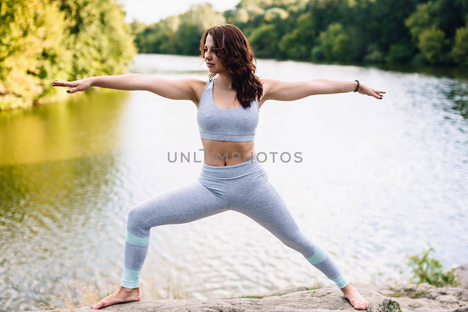 Pretty woman doing yoga exercises in the park by OnPhotoUa