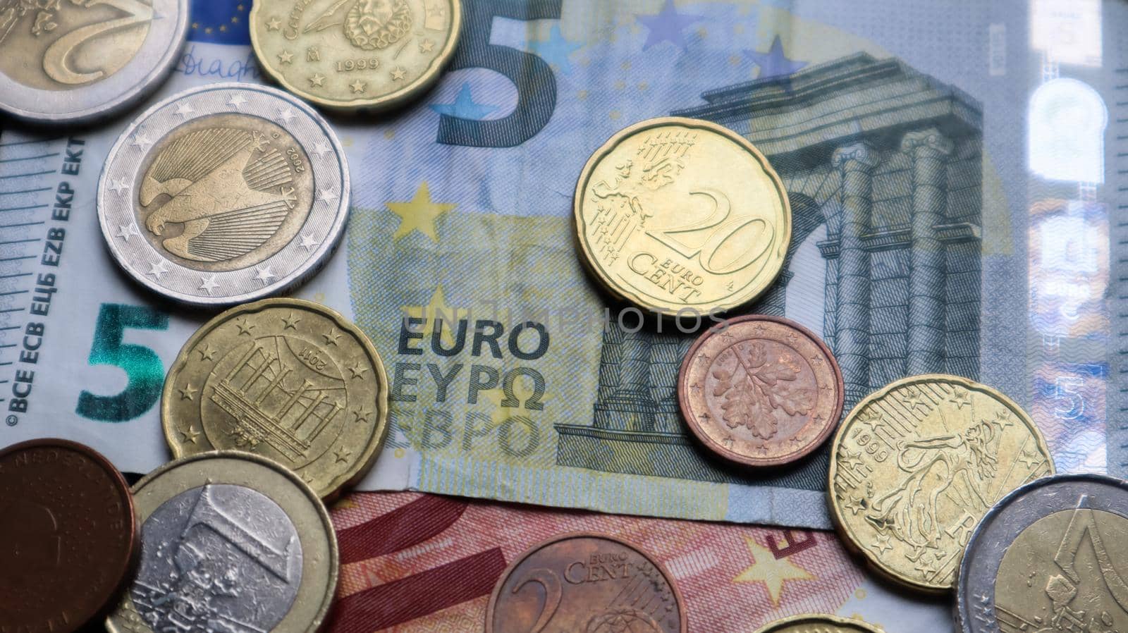A few metal coins and paper notes of the European Union. Euro cash closeup