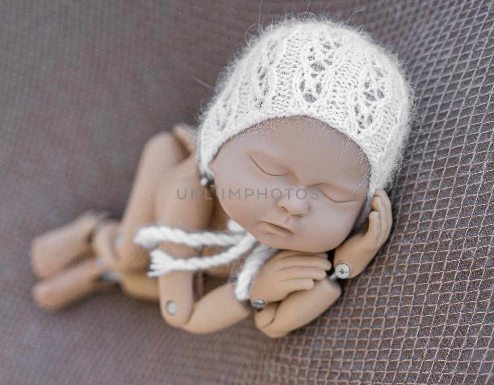 Precisely accurate mannequin of newborn in a hat for photo practicing