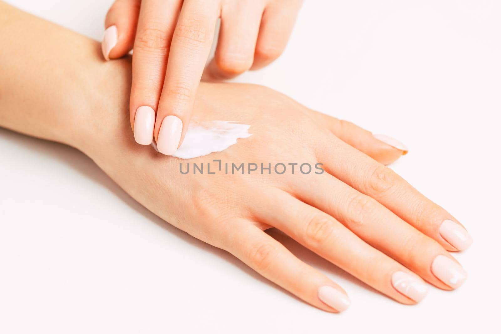 Woman’s hands applying moisturizing skincare cream. by alexAleksei