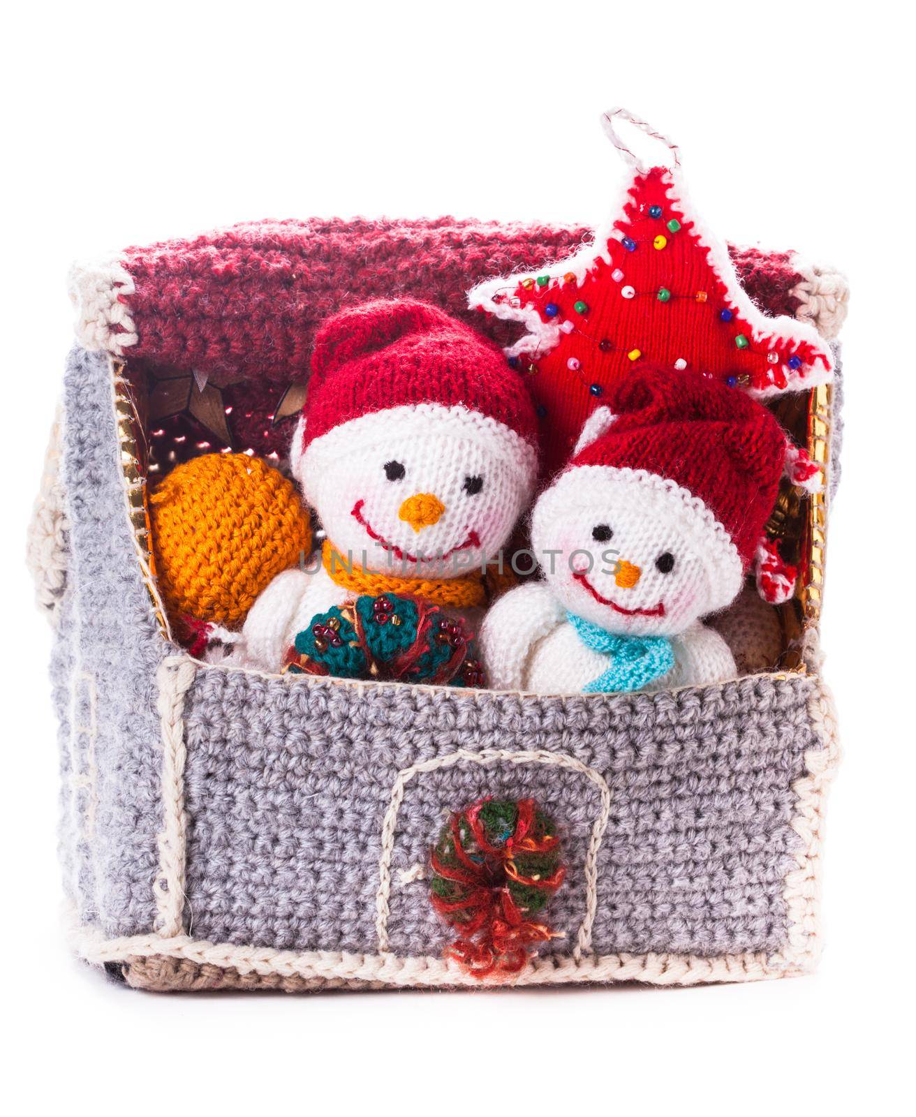 Two knitted christmas snowmen in a house and handmade christmas tree