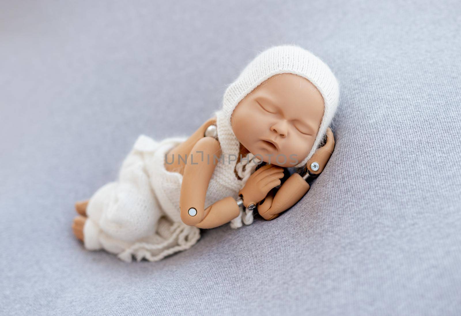 Doll mannequin of newborn baby for posing training photographer practice. Concept of infant cute photosession